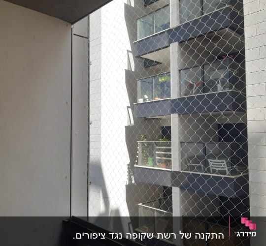 רשת הגנה מותקנת על מרפסת בניין מגורים